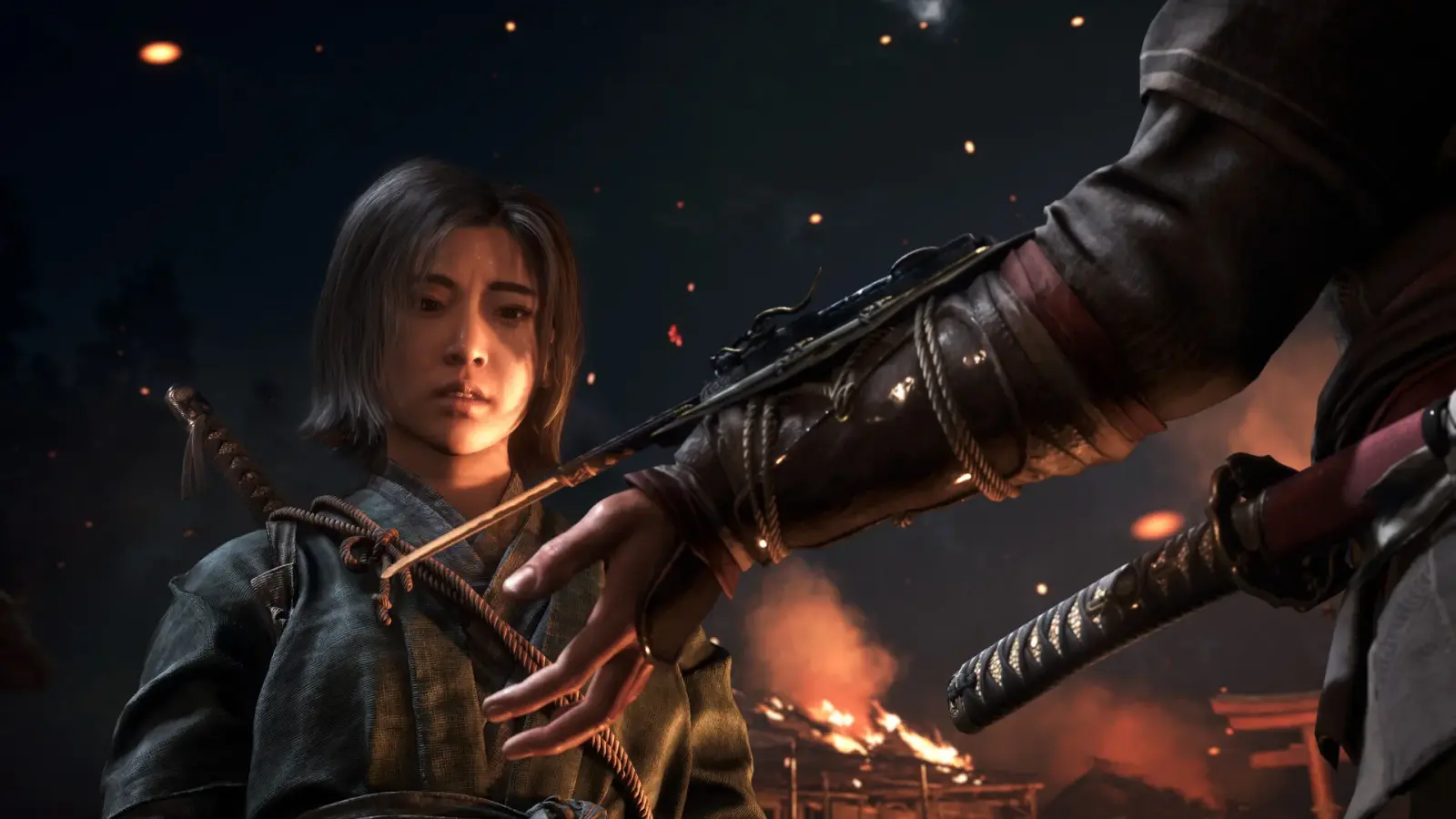 Naoe moves through a dark Japanese stronghold while preparing to approach nearby enemies.
