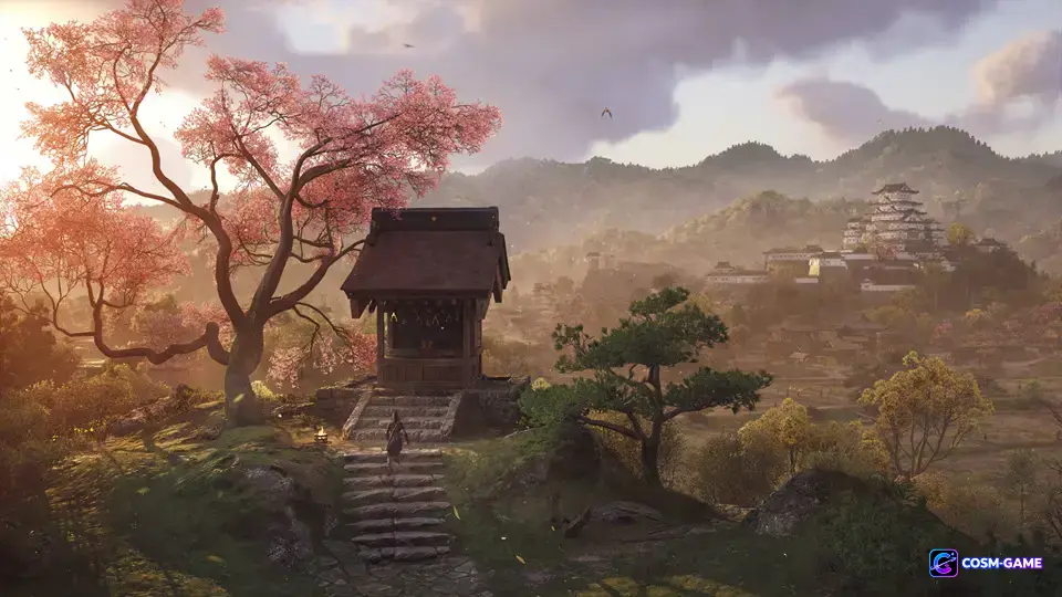 A shrine and cherry blossoms overlook a castle town and mountains in spring.