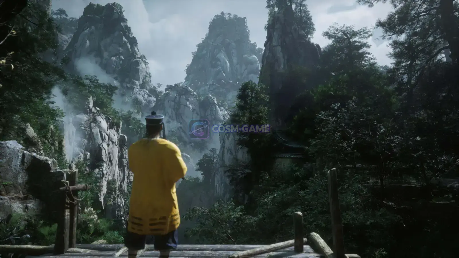 A yellow-robed figure overlooks steep misty mountains and dense forest.