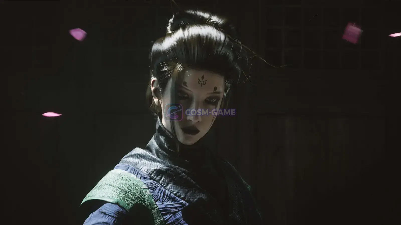 A dark-haired woman in layered clothing stands as pink petals drift through a dark room.