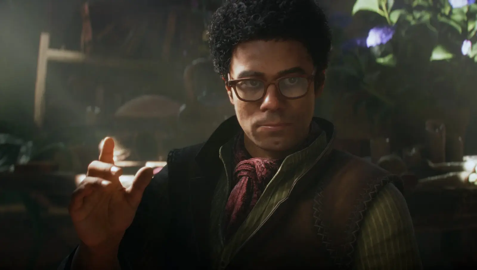 Dave gestures while wearing glasses and layered clothing inside a warmly lit room.