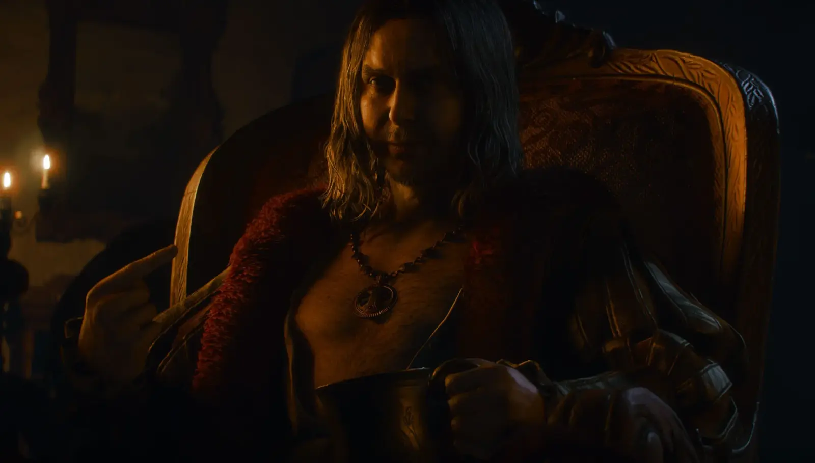 Humphry sits in an ornate chair holding a cup inside a room illuminated by candlelight.