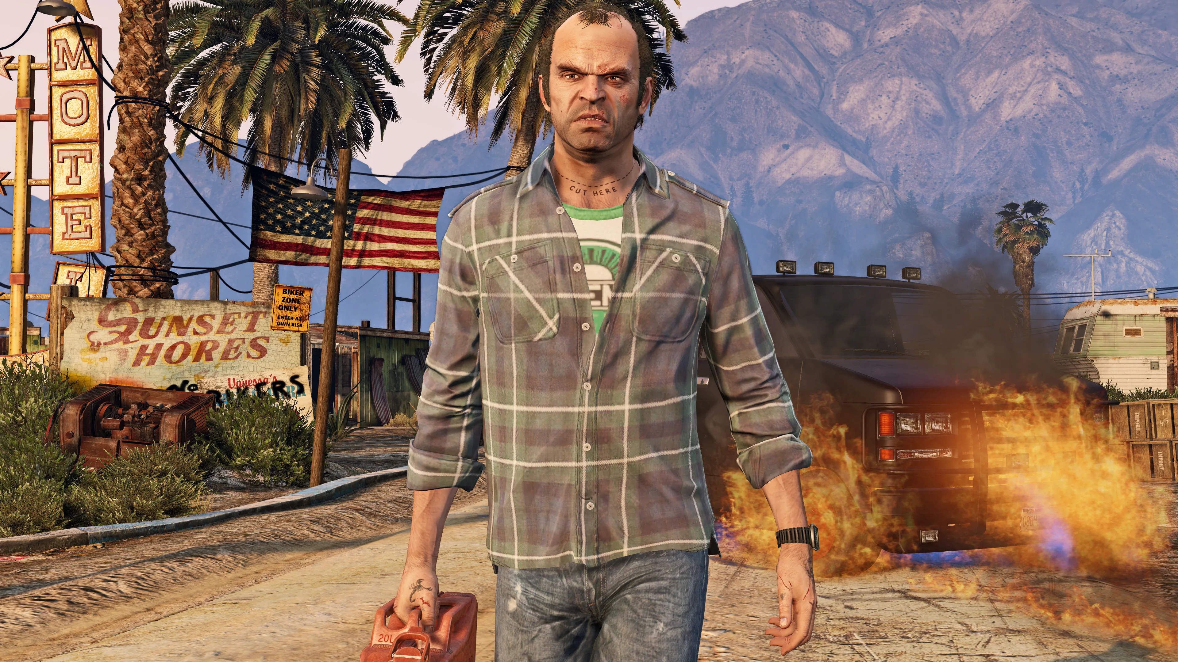 Trevor walks toward the camera carrying a fuel can while a vehicle burns behind him.