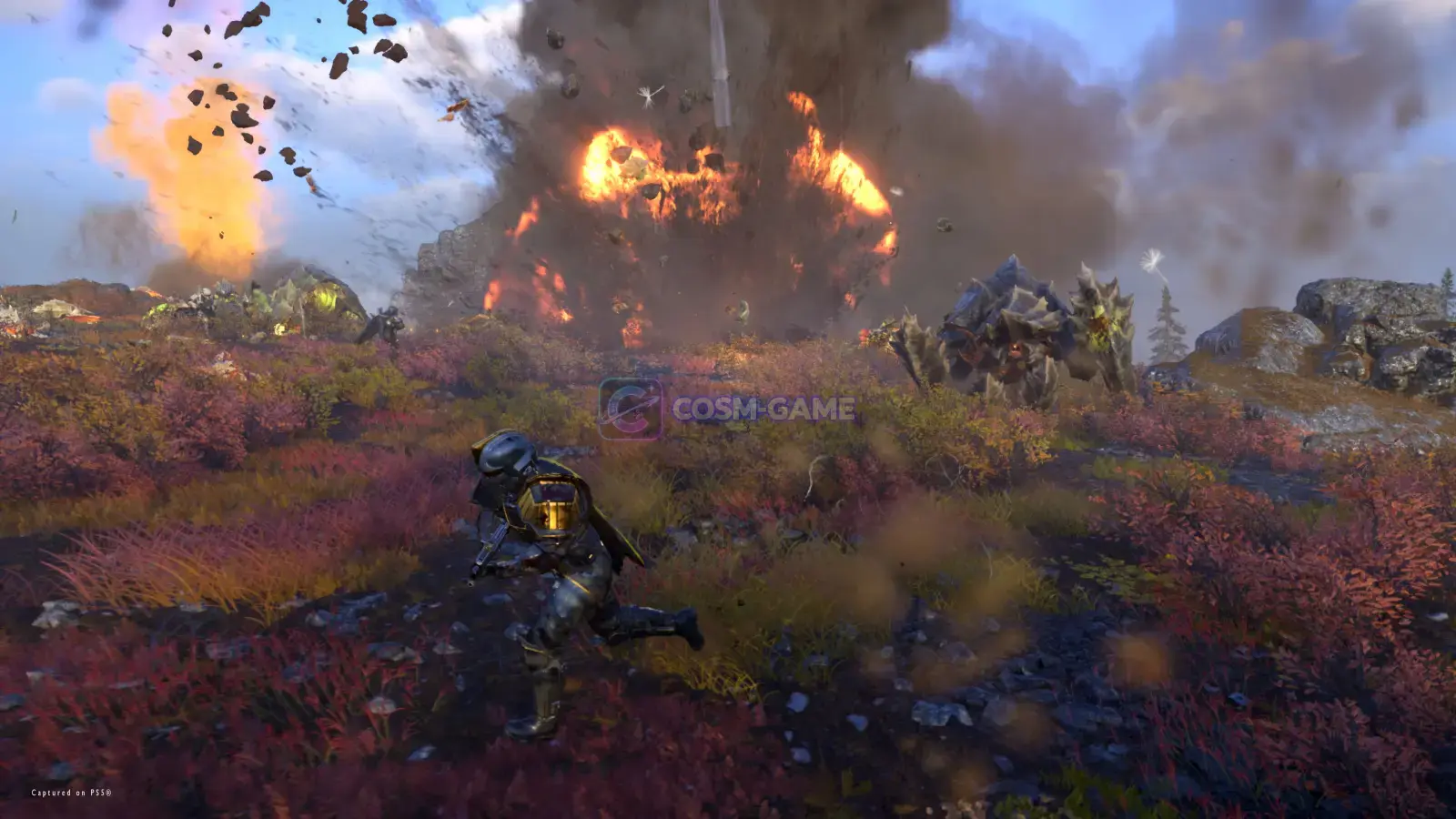 Helldivers fight amid bright explosions on an alien battlefield.