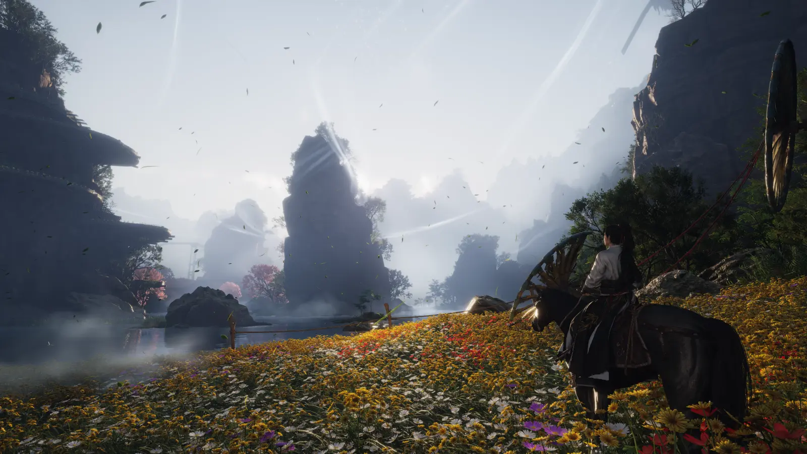 A rider pauses on horseback in a flower-filled valley beside water, towering rock formations, and elevated wooden structures.